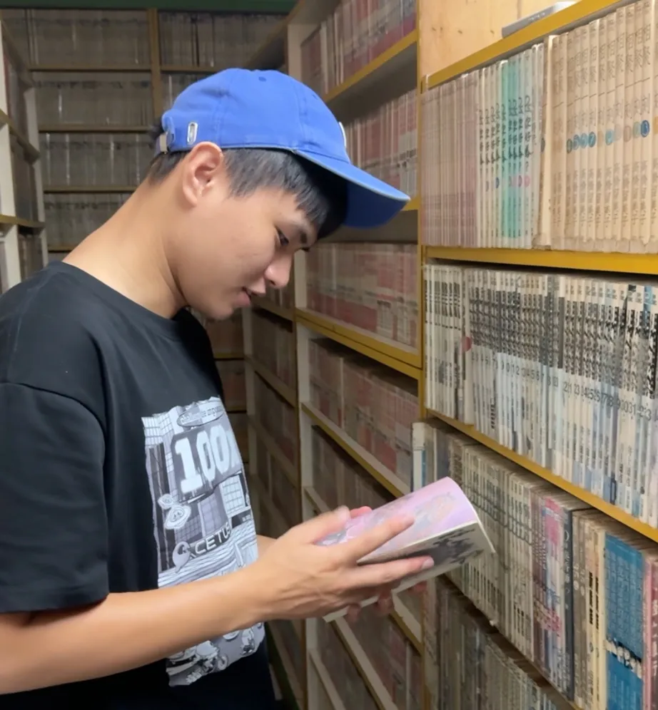 在皇冠租書城的漫畫書牆前挑書,整面書架從地板排到天花板,滿滿都是漫畫與小說